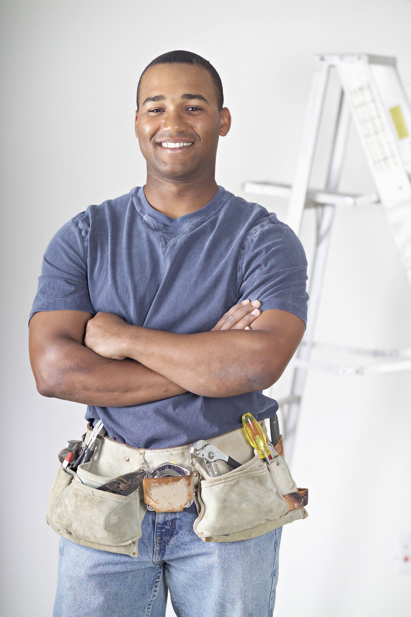happy contractor wearing tool belt with arms crossed